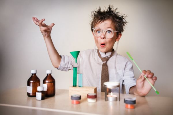 Crazy scientist. Young boy performing experiments