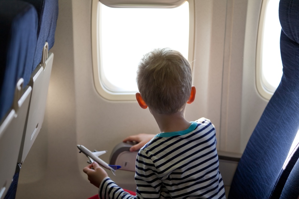 Boy sitting in plane looking out the window