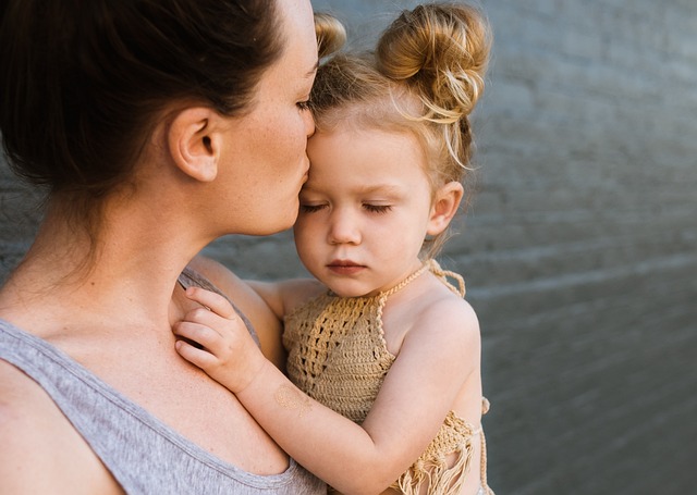 Mother holding her small daughter saying goodbye